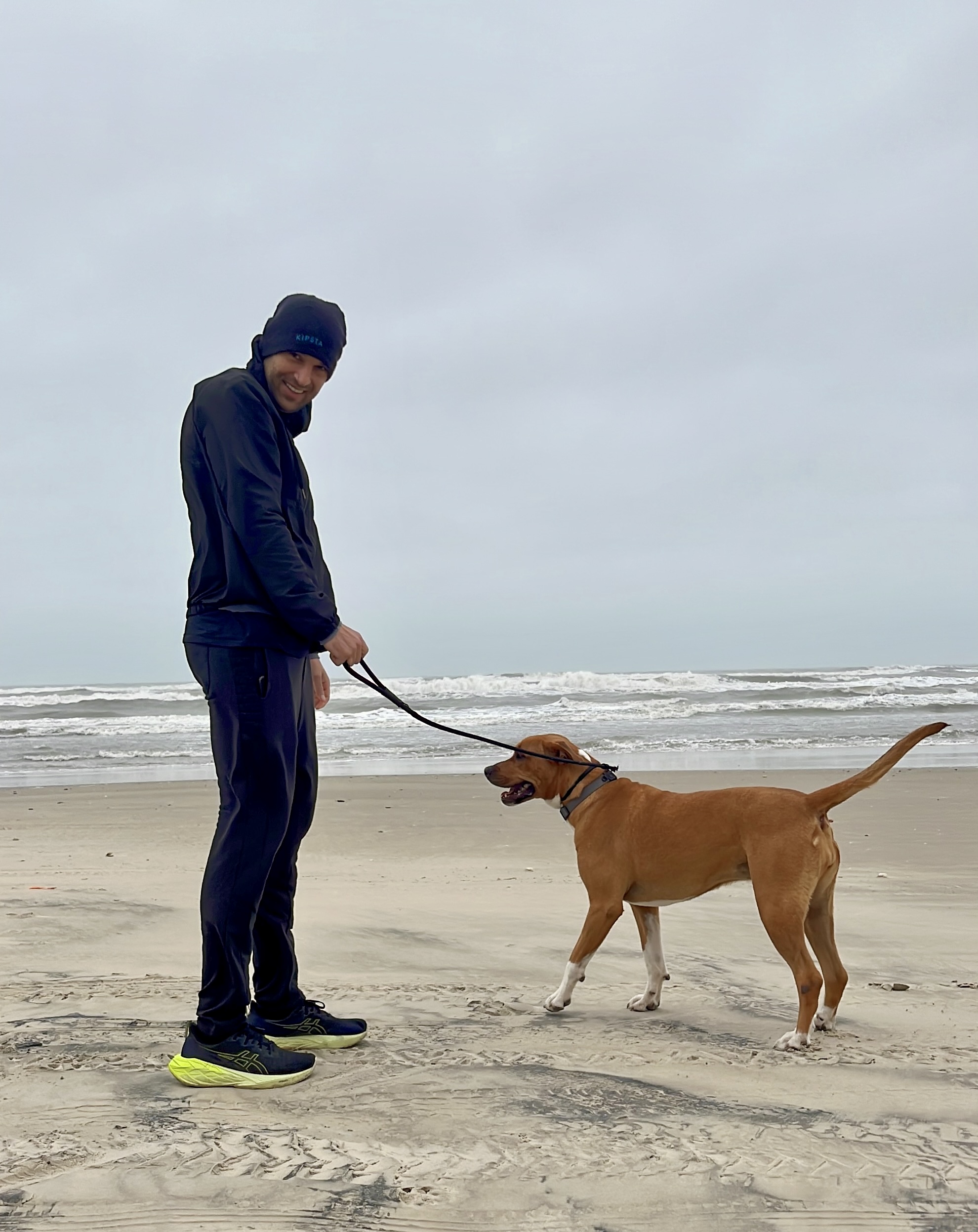 Henrique walking his dog on the beach